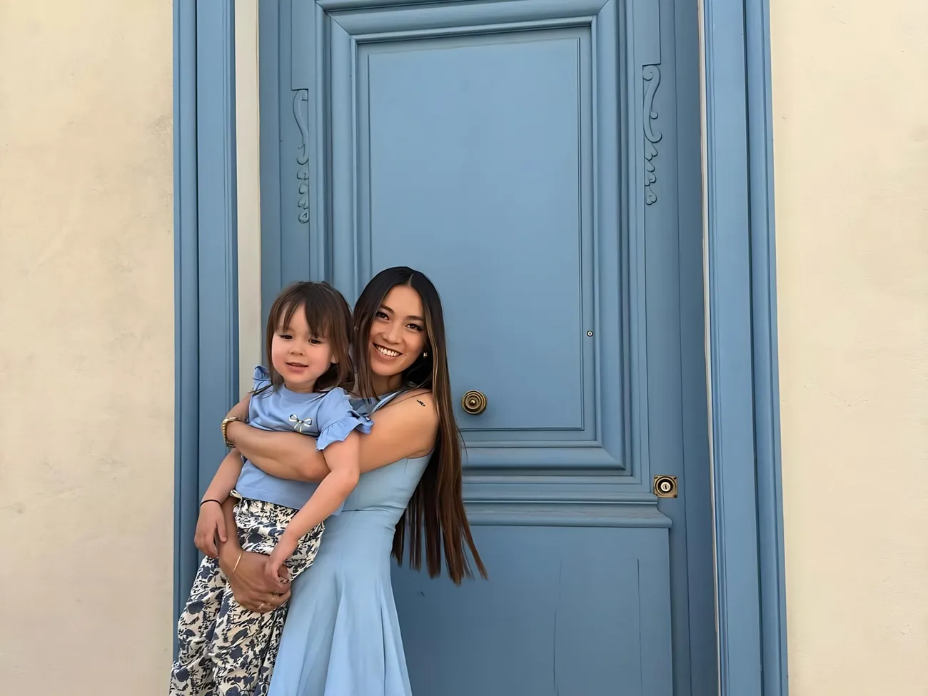 Candice et sa fille Lilia devant une porte bleue